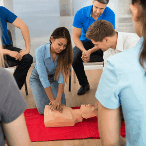 Group learning CPR techniques on mannequin