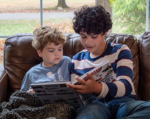 Older sibling reading picture book to child