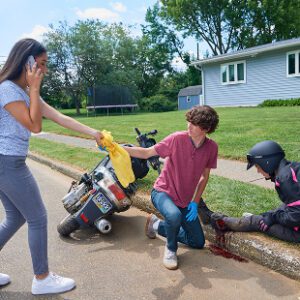 Two people assisting injured motorcycle rider roadside