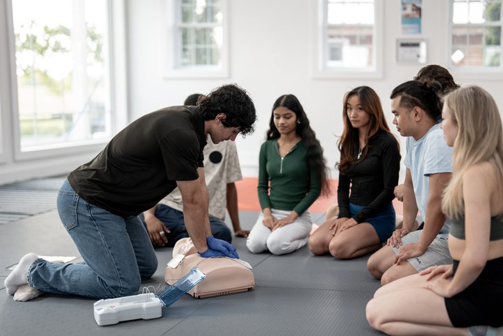 Group CPR training with mannequin and AED